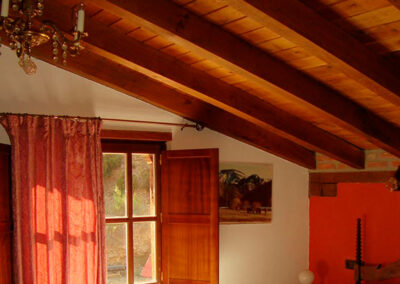 Vista del techo con vigas de madera, ventana con contraventanas, claridez